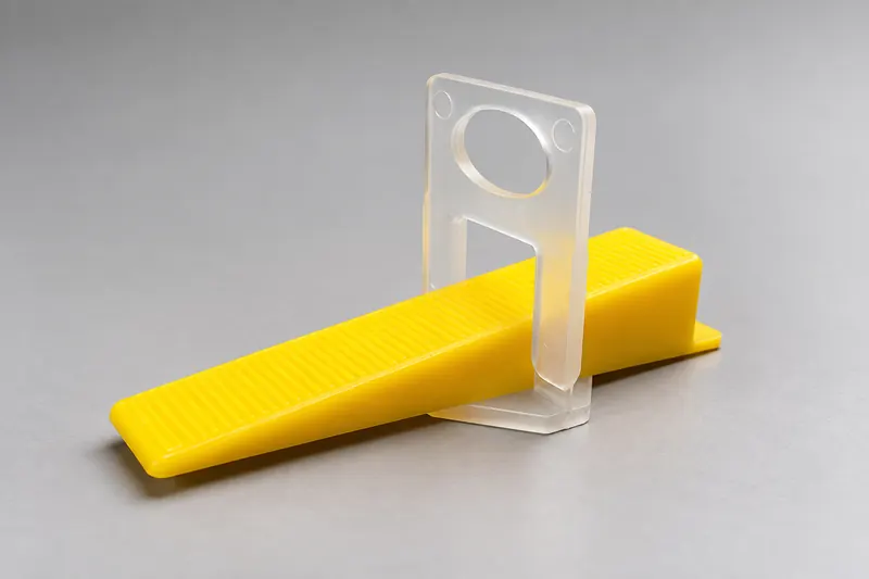 Clear tile leveling clip with a yellow ribbed wedge